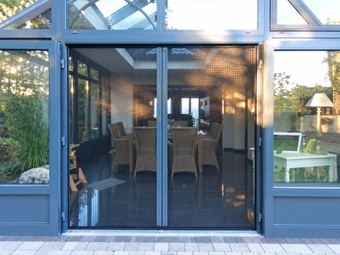 Porte vitrée munie d’une moustiquaire avec vue sur la terrasse